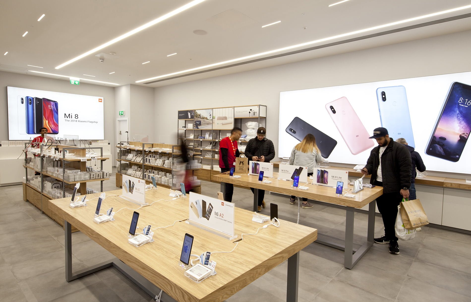 Interior design of Xiaomi flagship Mi store with customers using the products