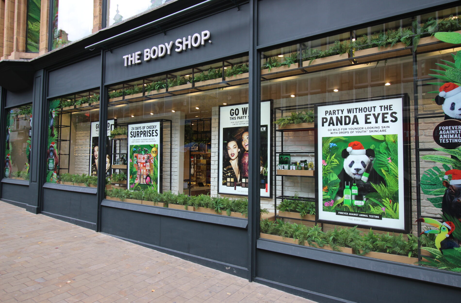 exterior of the body shop store with 'party without the panda eyes' window display Beyond London The Body Shop - Retail strategy and Retail Design Store Design Point of Sale Design Retail guidelines Rollout Customer Experience design